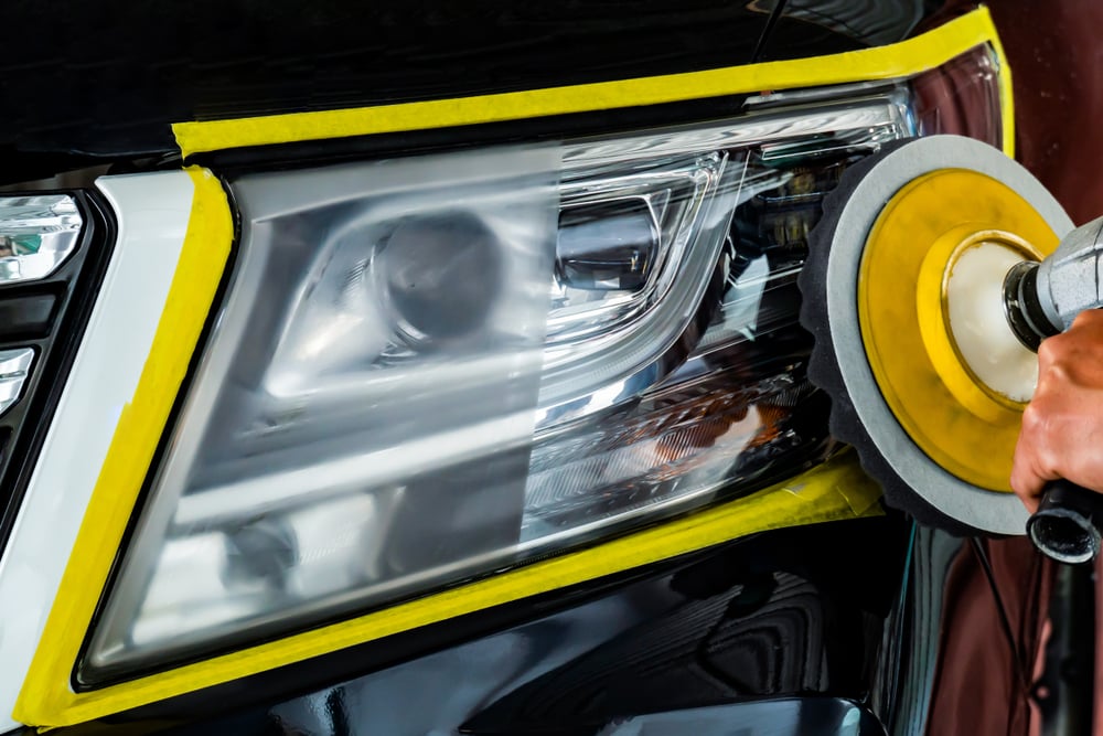 Professional headlight restoration process showing polishing machine restoring car headlight